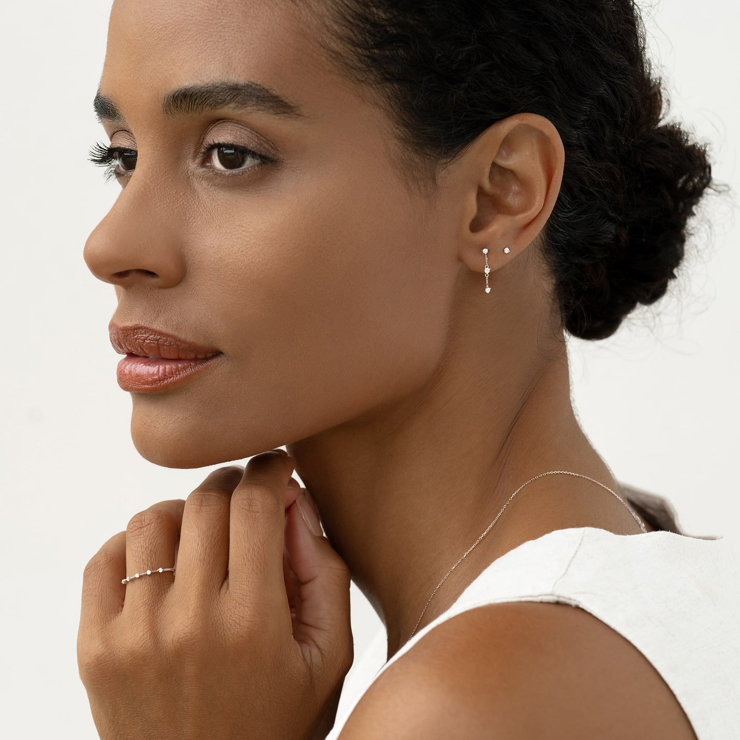 Close-up of a woman wearing Diamond Drop Earrings White Gold - Alessia with a delicate 14k white gold cable chain design