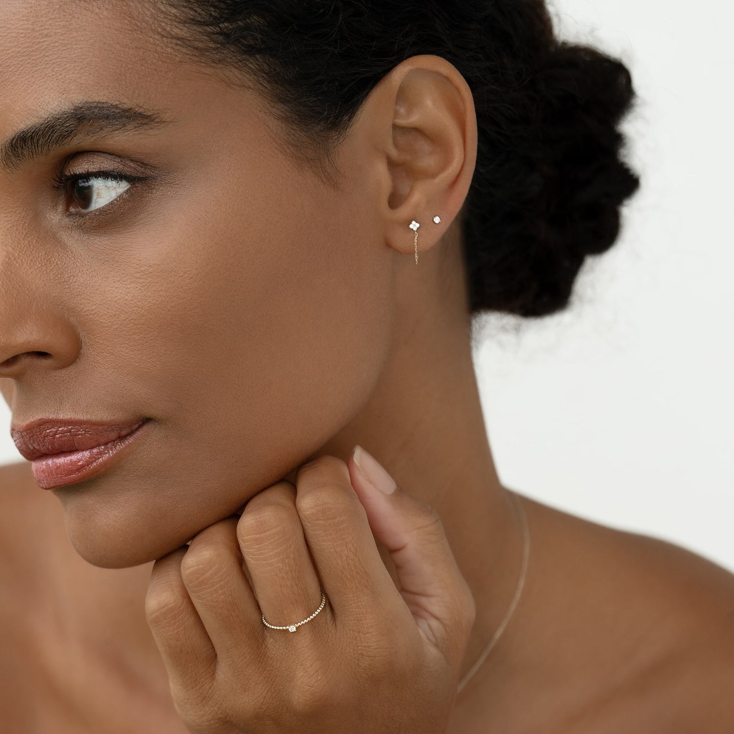 Close-up of a woman wearing Diamond Chain Earrings White Gold - Alva with delicate star diamond design on white background