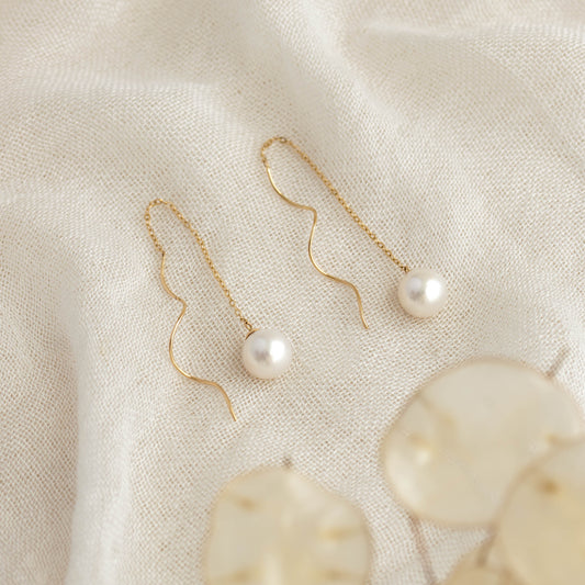Pearl Threader Earrings 14k Gold - Anthea with freshwater pearls on delicate gold chains displayed on cream fabric