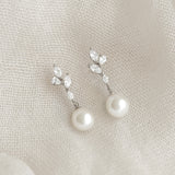Close-up of Pearl Drop Earrings Silver - Ariana featuring baroque pearls and cubic zirconia on a textured fabric background