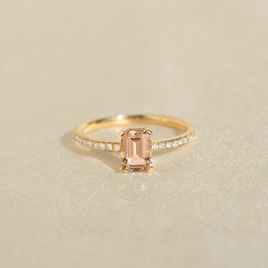 Close-up of Baguette Morganite and Diamond Ring 14k Gold - Safiya with rectangular peach gemstone and pavé diamond band on beige background