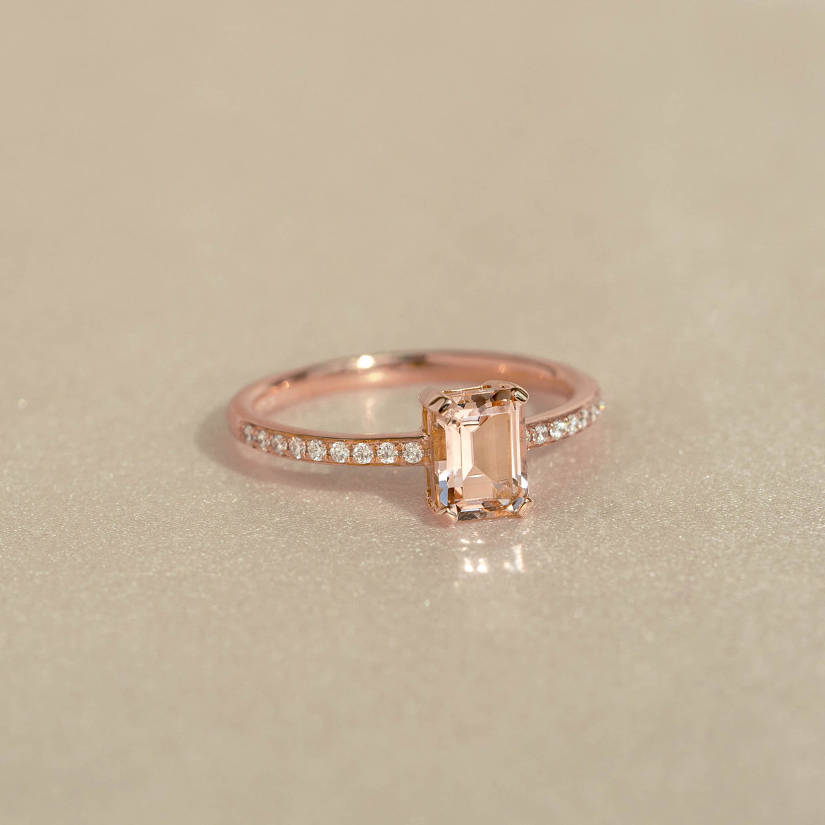 Close-up of Baguette Morganite and Diamond Ring Rose Gold - Safiya with sparkling stones on a soft beige background