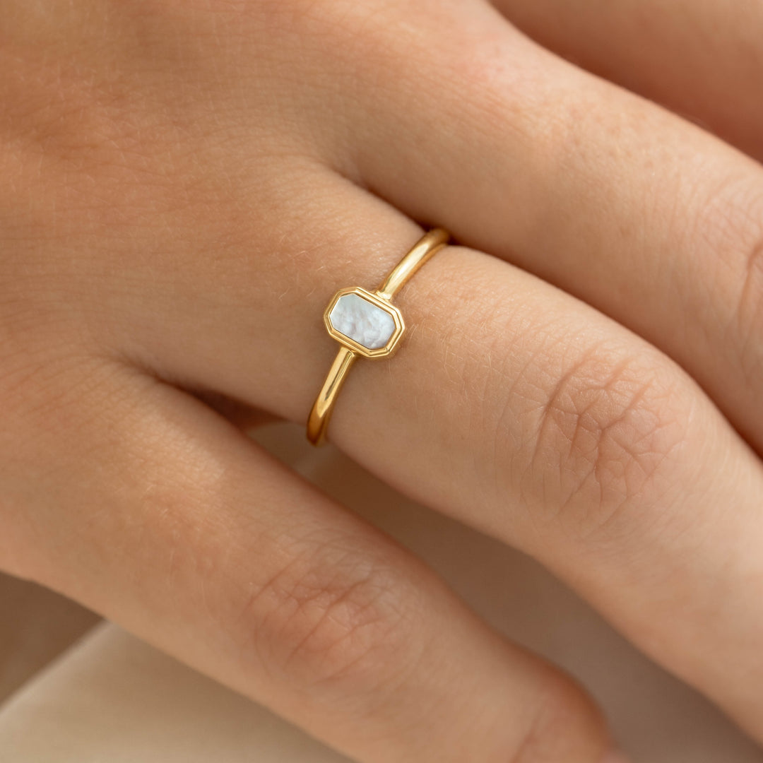 Close-up of a hand wearing Mother of Pearl Ring 14k Gold - Maren with a delicate mother of pearl inlay on a gold band