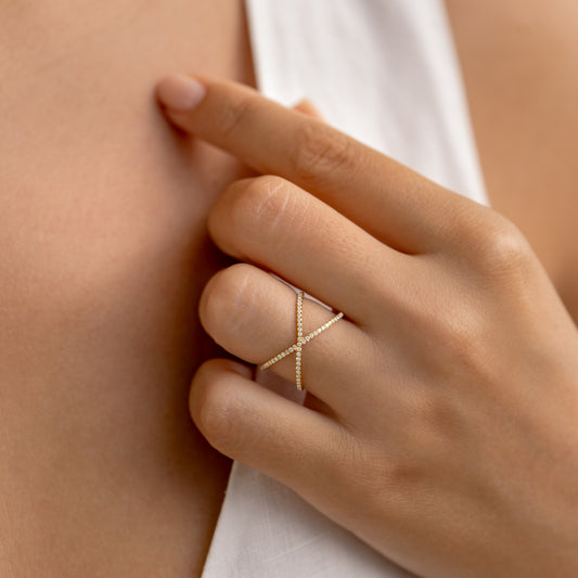 Close-up of hand wearing Criss Cross Diamond Eternity Ring - Mattea with two rows of diamonds on a neutral background