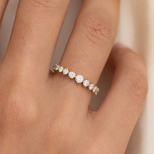 Close-up of hand wearing Graduated Diamond Ring 14k Gold - Giselle with 11 round diamonds on a gold band