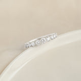 Close-up of the Graduated Diamond Ring White Gold - Giselle with 11 round diamonds on a white gold band on beige background