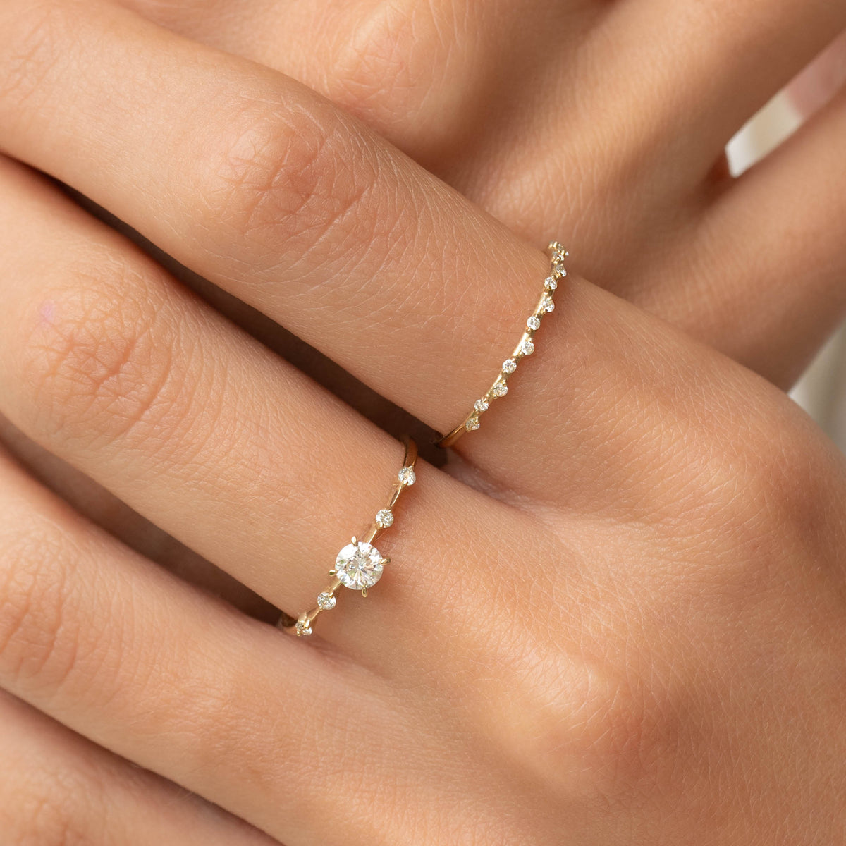 Close-up of hand wearing Round Diamond Ring 14k Gold - Rocio with round center diamond and delicate side stones