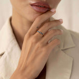 Close-up of a woman wearing the Sapphire Half Eternity Ring 14k Gold - Capriana with pear-cut blue sapphires on hand