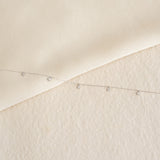 Close-up of 5-Diamond Necklace White Gold - Bette with five bezel-set diamonds on a delicate chain on beige background