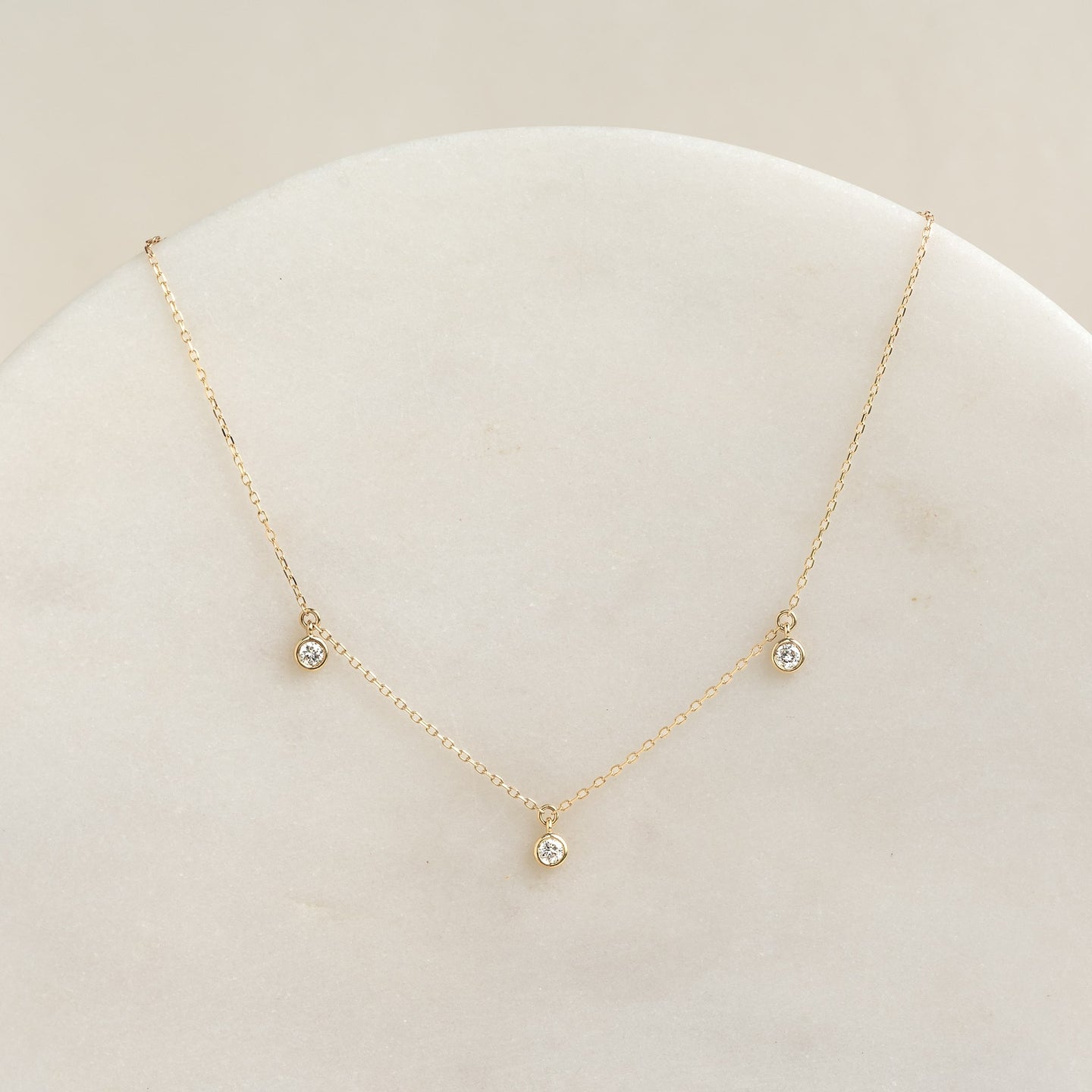 Close-up of the 3-Diamond Necklace 14k Gold - Eira featuring three bezel-set diamonds on a delicate gold chain