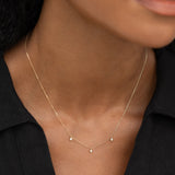 Close-up of the 3-Diamond Necklace 14k Gold - Eira featuring three bezel-set diamonds on a delicate chain worn on a neck