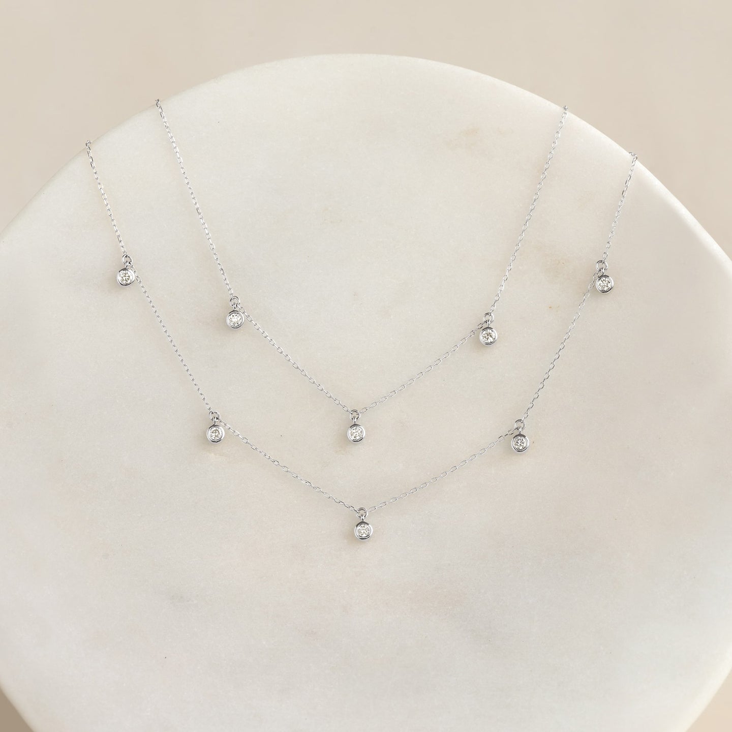 5-Diamond Necklace White Gold - Bette featuring five bezel-set diamonds on a delicate white gold chain on a neutral surface
