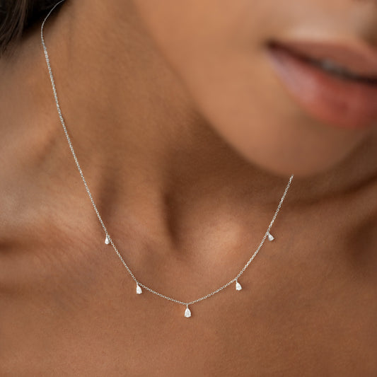 Close-up of Pear Cut Diamond Pendant Necklace White Gold - Sylvie worn on a woman’s neck against neutral skin tone