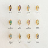 Array of gold vermeil huggie earrings with various birthstones including June Birthstone Huggie Earrings - Moonstone on beige background