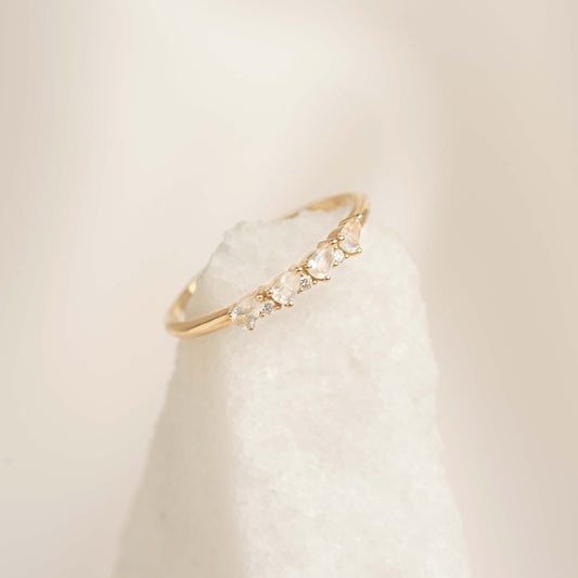 Close-up of June Birthstone Pear Ring 14k Gold Moonstone and Diamond on white textured stone with soft neutral background