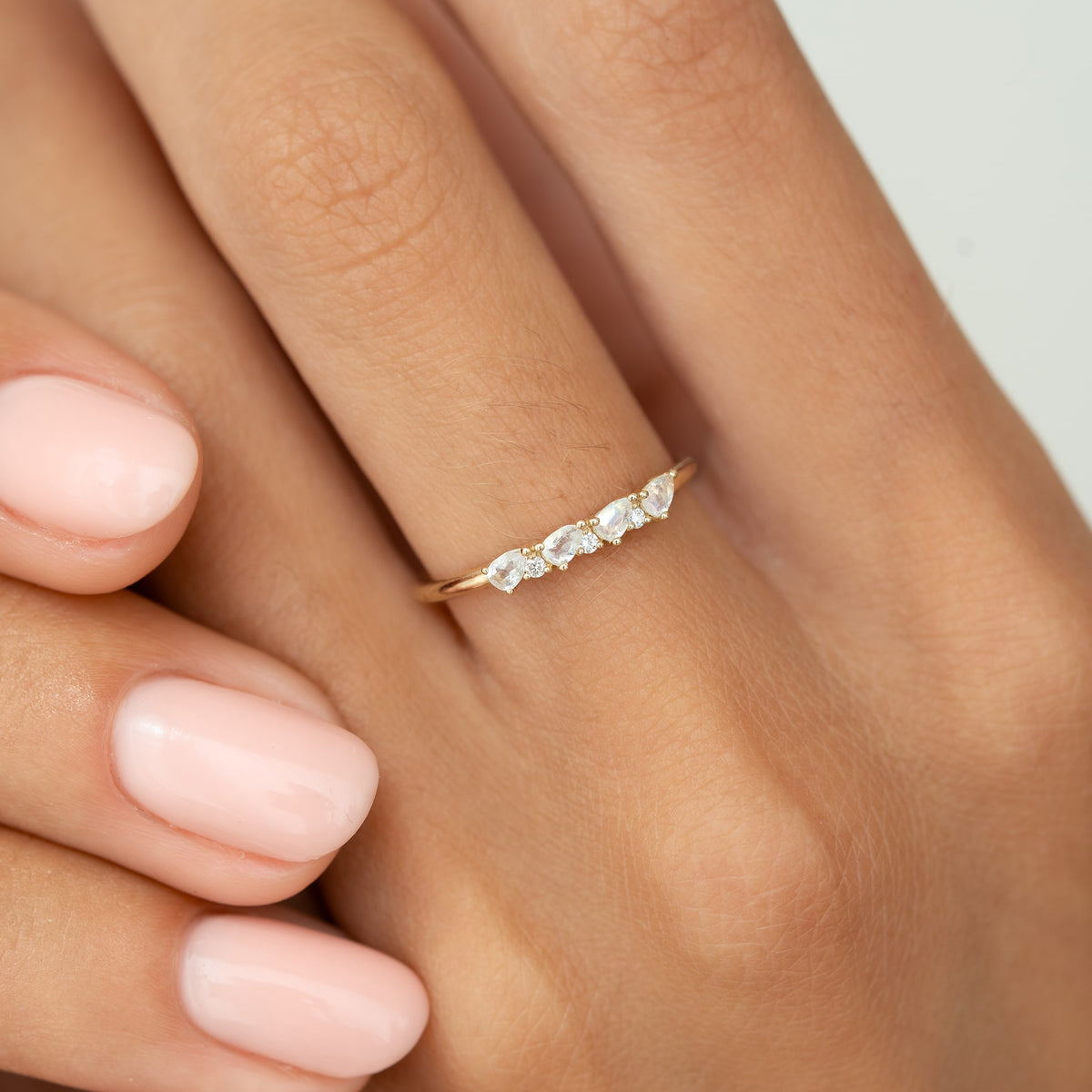 Close-up of June Birthstone Pear Ring 14k Gold Moonstone and Diamond worn on finger with soft pink nails