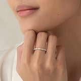 Close-up of a hand wearing the Marquise and Round Diamond Ring - Aurelia with 14k yellow gold band near the chin