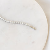 Close-up of Diamond Tennis Bracelet White Gold (1.501 ct tw) - Mirella laid on a smooth white circular surface