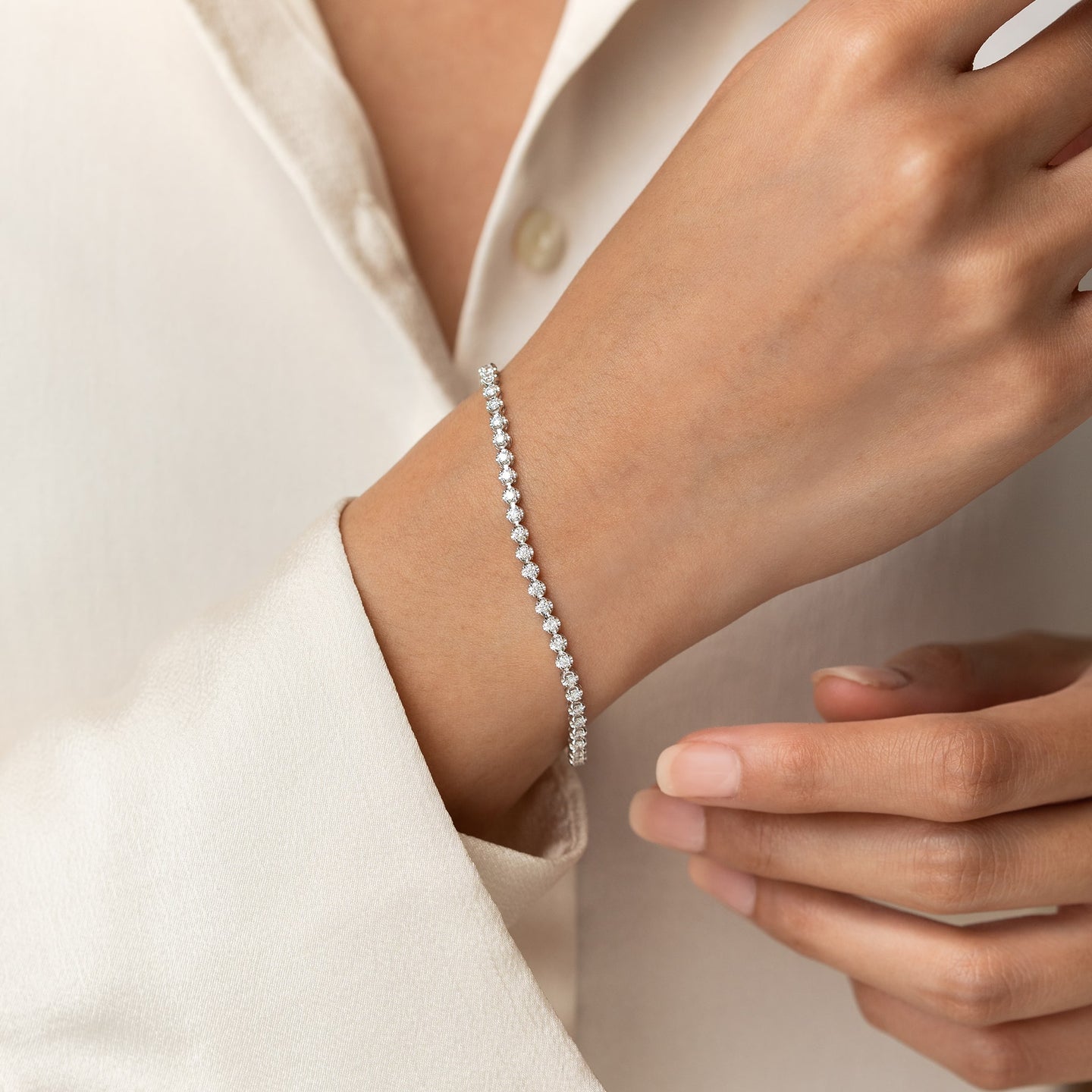 Close-up of a wrist wearing the Diamond Tennis Bracelet White Gold (1.501 ct tw) - Mirella against a neutral background