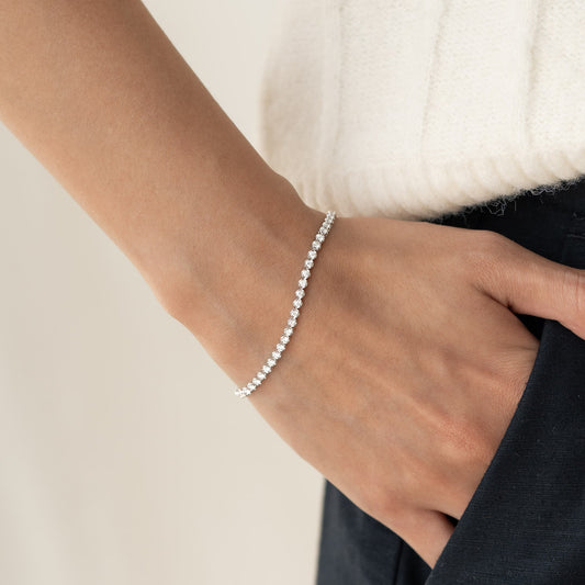 Close-up of a wrist wearing the Diamond Tennis Bracelet White Gold (1.501 ct tw) - Mirella with sparkling diamonds