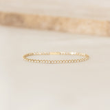 Close-up of a Diamond Tennis Bracelet 14k Gold (1.62 ct tw) - Mirella resting on a light beige surface