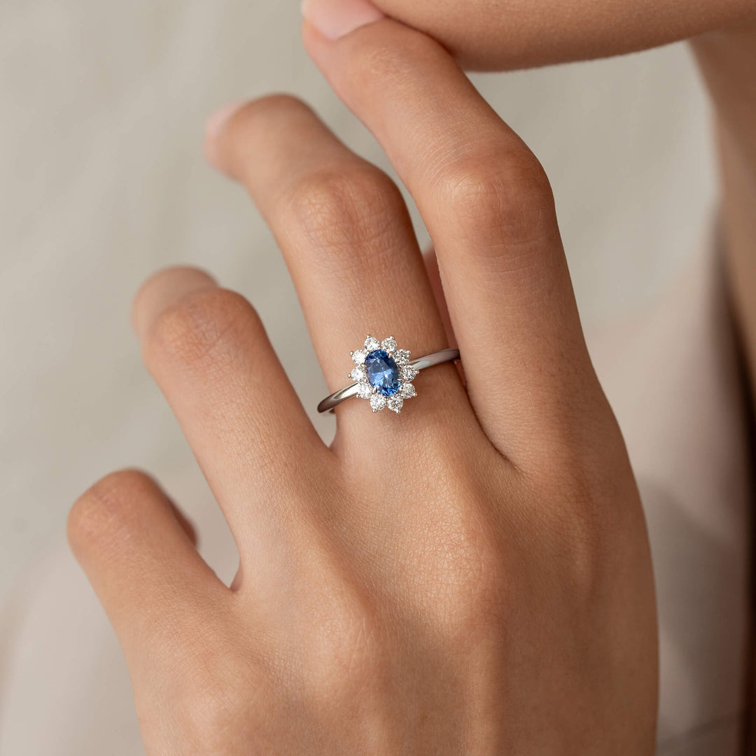The 14k White Gold ring is worn on the middle finger, which is gently raised toward the person's chin.