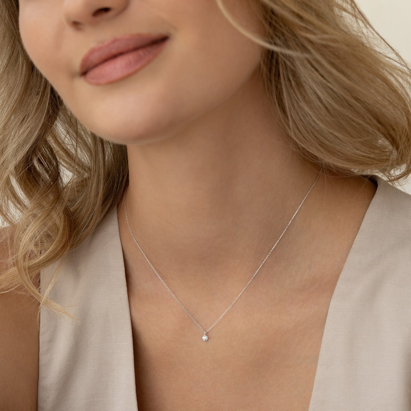 Close-up of a woman wearing a Diamond Pendant Necklace White Gold - Atiana on a delicate white gold chain against a neutral background