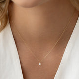 Close-up of a woman wearing the Diamond Pendant Necklace 14k Gold - Atiana with a delicate chain on bare skin