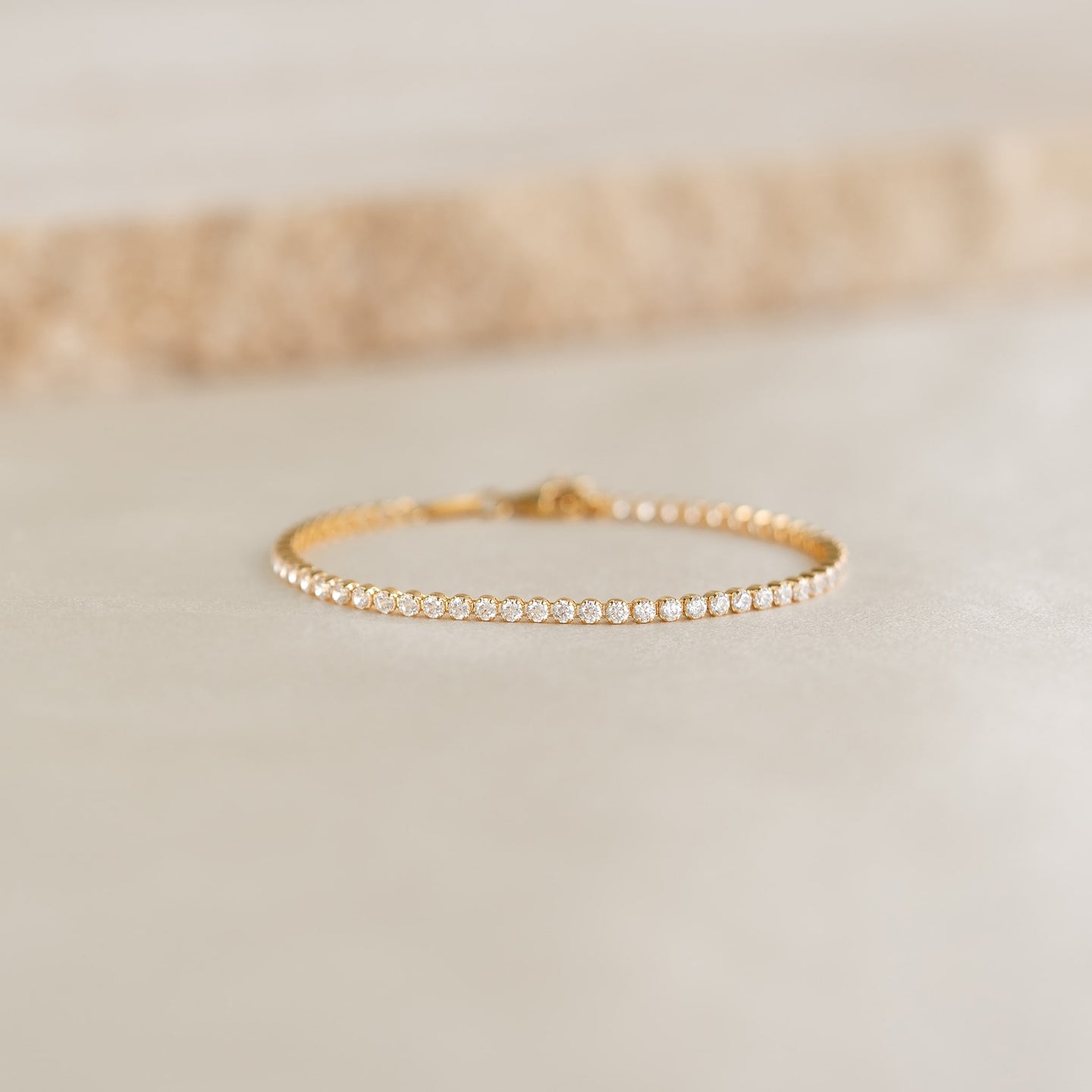 Close-up of the Tennis Bracelet - Audrey featuring sparkling cubic zirconia stones set in gold vermeil on a neutral surface