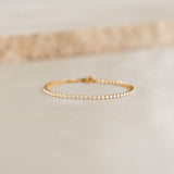 Close-up of the Tennis Bracelet - Audrey featuring sparkling cubic zirconia stones set in gold vermeil on a neutral surface