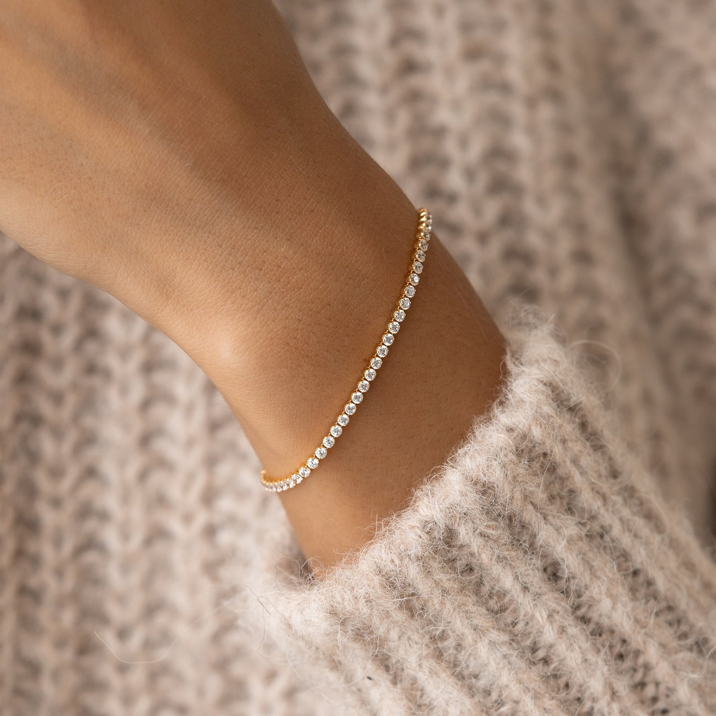 Close-up of a wrist wearing the Tennis Bracelet - Audrey with sparkling cubic zirconia stones and gold vermeil finish