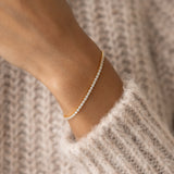Close-up of a wrist wearing the Tennis Bracelet - Audrey with sparkling cubic zirconia stones and gold vermeil finish