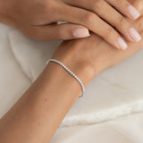 Close-up of a wrist wearing the Tennis Bracelet Silver - Audrey with sparkling cubic zirconia stones on a soft background