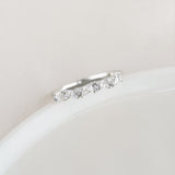 Close-up of the Marquise and Round Diamond Ring White Gold - Celia resting on a smooth white surface with soft lighting