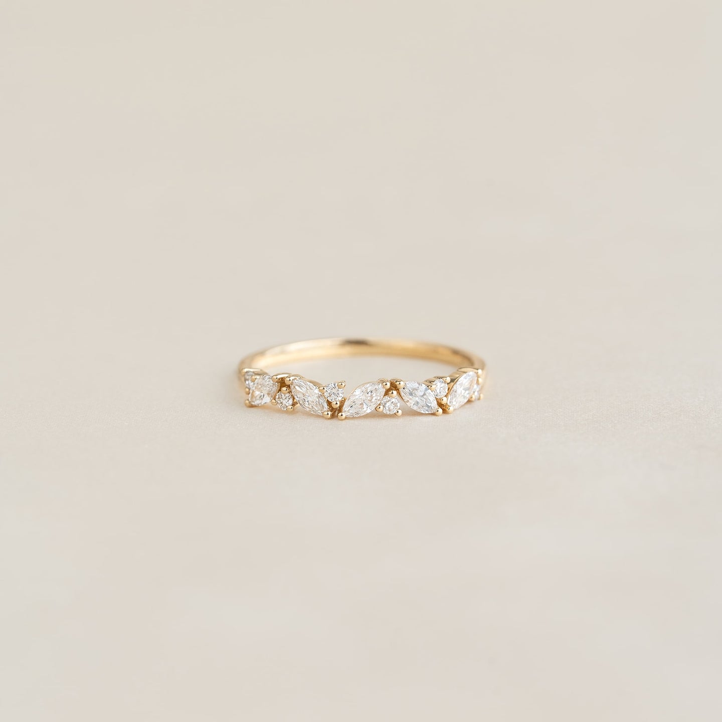Close-up of Marquise and Round Diamond Ring 14k Gold - Celia with floral diamond details on a neutral background