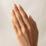 Close-up of a hand wearing a Diamond Eternity Ring White Gold with a circle of sparkling diamonds on a neutral background