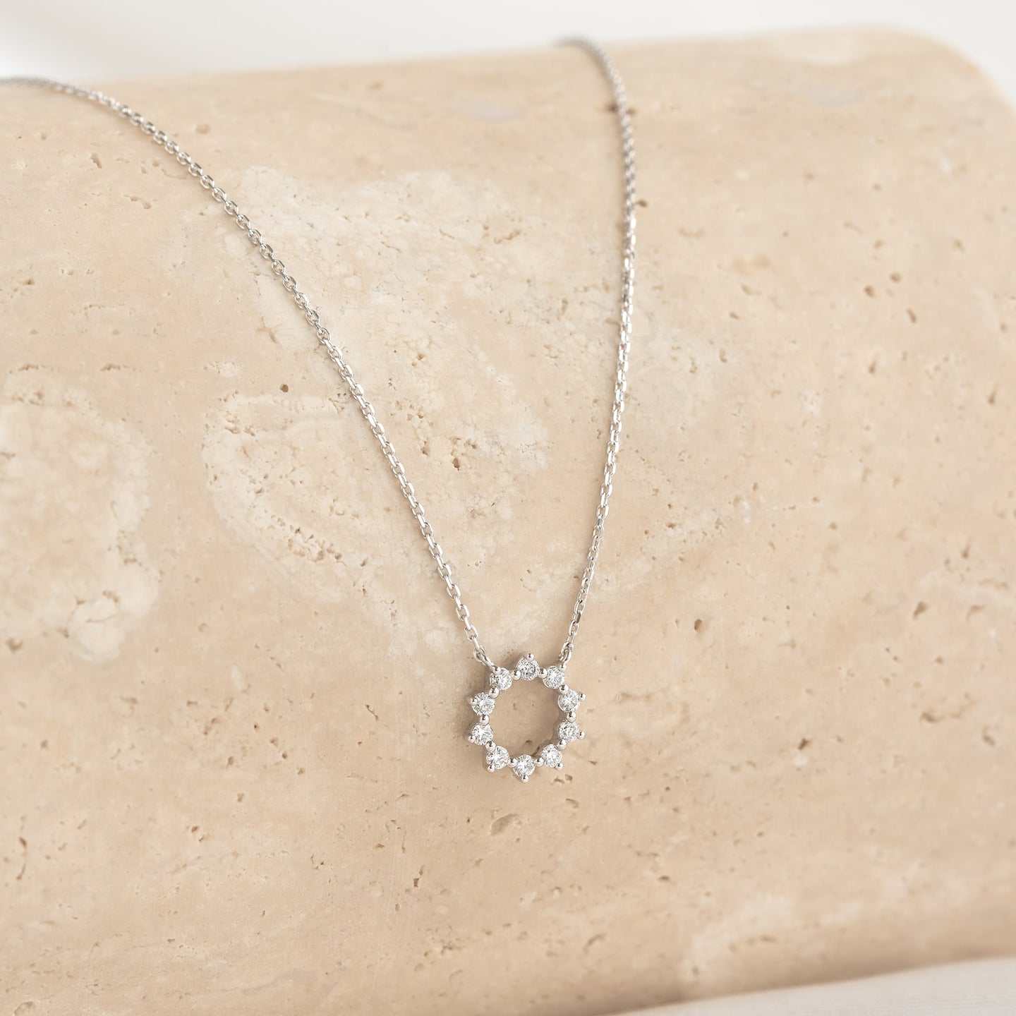 Close-up of the Diamond Sun Necklace White Gold - Leda featuring a delicate sun pendant with sparkling diamonds on a white gold chain