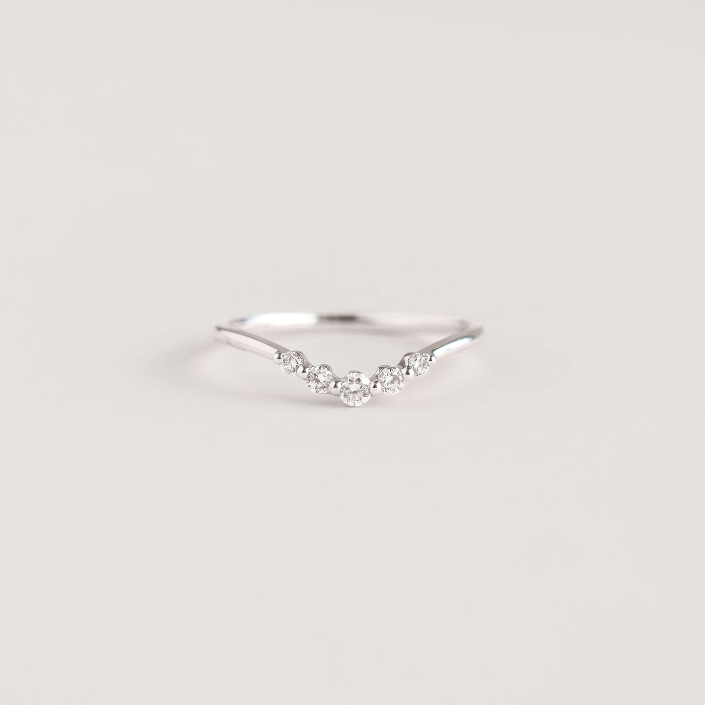 Close-up of a Graduated Diamond V Ring White Gold - Liora with five graduated diamonds on a delicate band