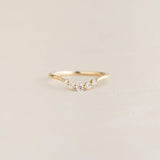 Close-up of the Graduated Diamond V Ring 14k Gold - Liora with five diamonds on a delicate gold band on a neutral background