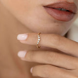 Close-up of hand holding the Graduated Diamond V Ring 14k Gold - Liora with five sparkling diamonds on gold band