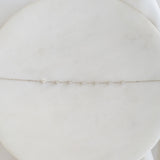 Close-up of Diamond Bracelet White Gold - Lyra featuring seven round diamonds on a delicate white gold chain against a soft white background