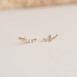 Close-up of Diamond Climber Stud Earrings 14k Gold - Rhea featuring small round diamonds on a soft beige surface