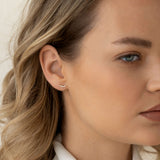 Close-up of a woman wearing Diamond Climber Stud Earrings 14k Gold - Rhea showing diamonds climbing along the earlobe