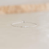 Close-up of a delicate Graduated Diamond Bracelet White Gold - Tamsin featuring five small diamonds on a fine chain