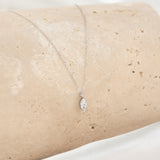 Close-up of a marquise diamond pendant on a delicate chain from the Marquise Diamond Necklace White Gold - Violetta displayed on stone