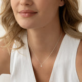 Close-up of a woman wearing a Marquise Diamond Necklace White Gold - Violetta with a delicate chain and pendant