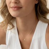 Close-up of a woman wearing Marquise Diamond Necklace 14k Gold - Violetta with a white sleeveless top against a neutral background