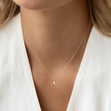 Close-up of a woman wearing the Marquise Diamond Necklace 14k Gold - Violetta with a delicate marquise diamond pendant