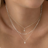 Close-up of a woman wearing the Marquise Diamond Necklace White Gold - Violetta with layered delicate white gold chains