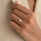 Close-up of hand wearing Oval Morganite and Diamond Ring 14k Gold - Demetria with soft beige fabric background